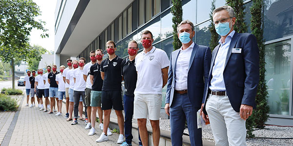 Hans-Jürgen Winkelmann und Axel Köver mit den Spielern vor dem St. Marien-Krankenhaus Siegen